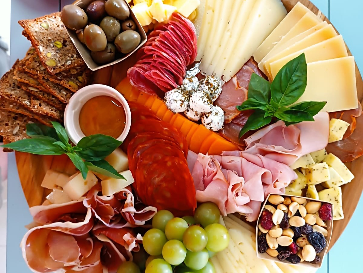 Tabla de jamones, quesos, aceitunas, uvas y frutos secos