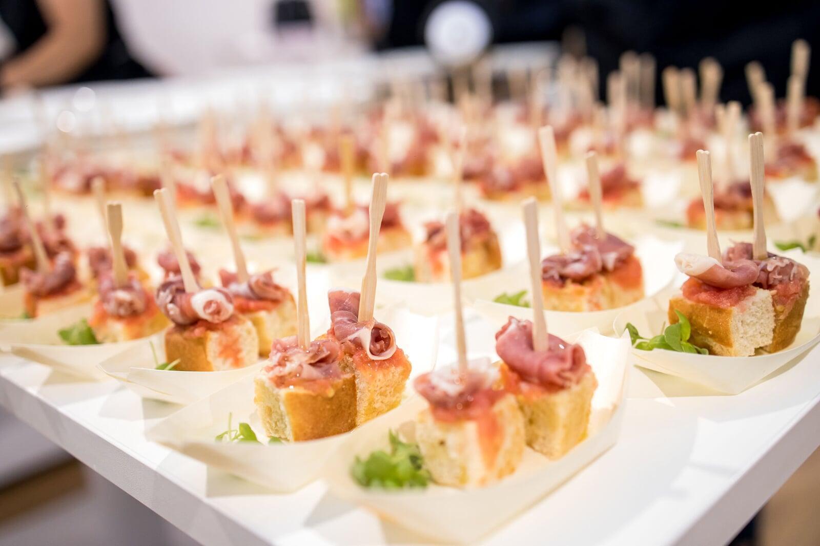 Bocadillos de pan con jamón serrano y arúgula servidos en bandeja
